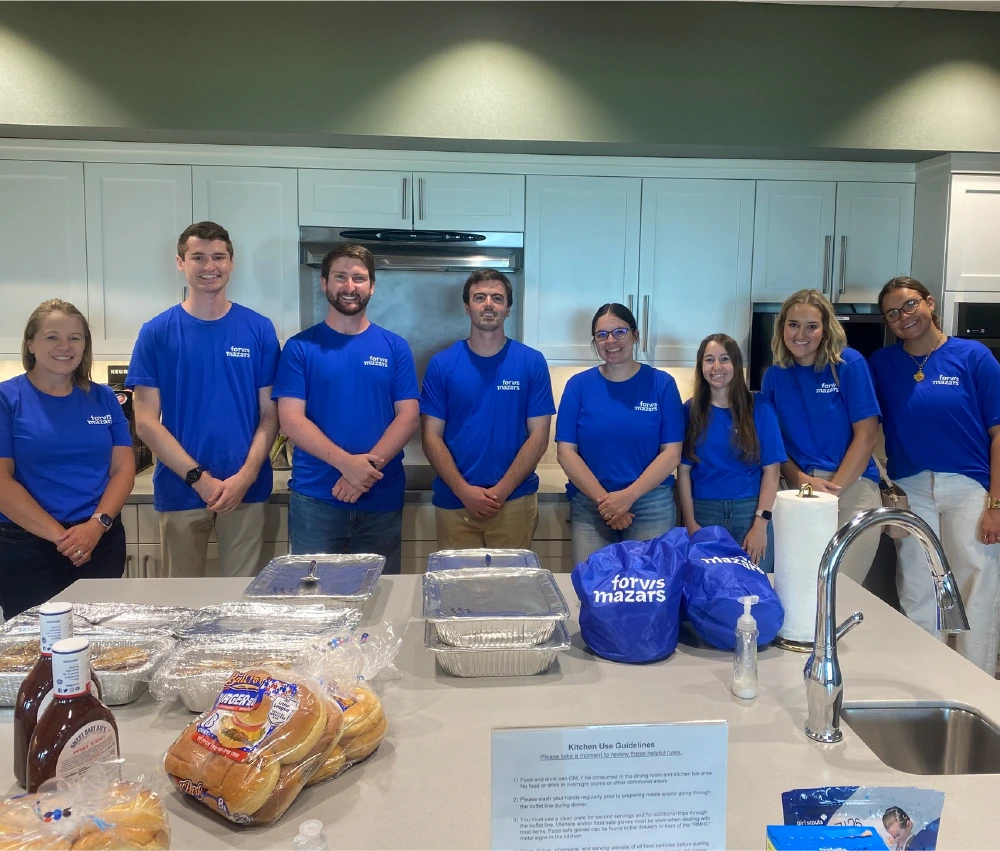group of volunteers gathered in kitchen all wearing matching shirts